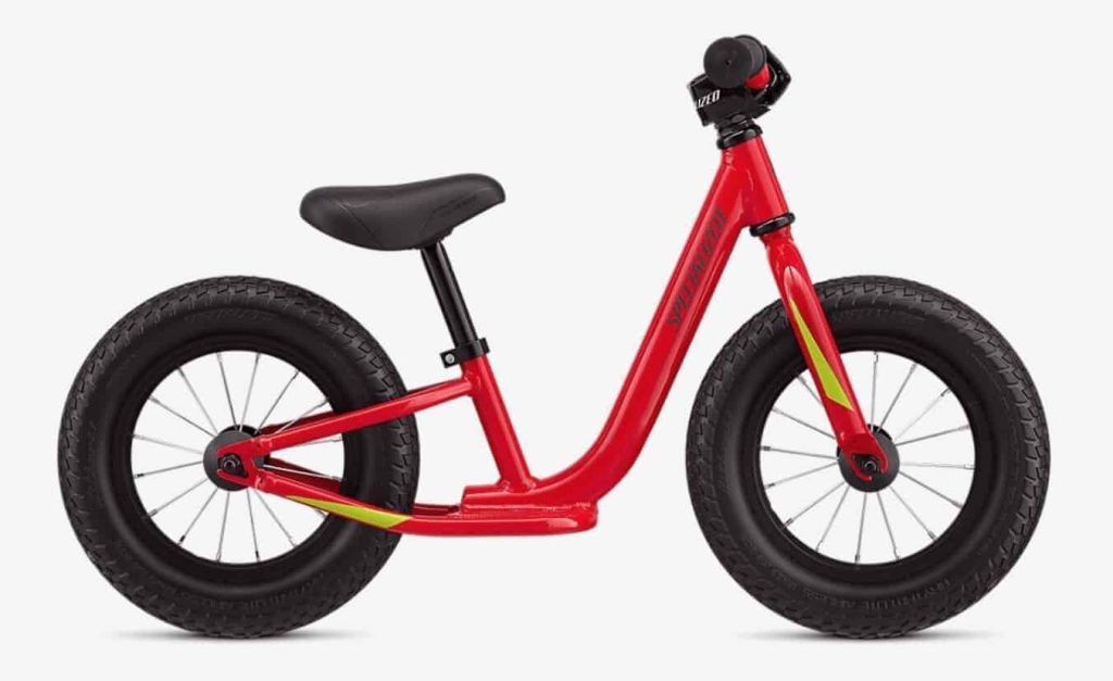 Rode loopfiets met dikke banden, ideaal voor kinderen die leren fietsen.