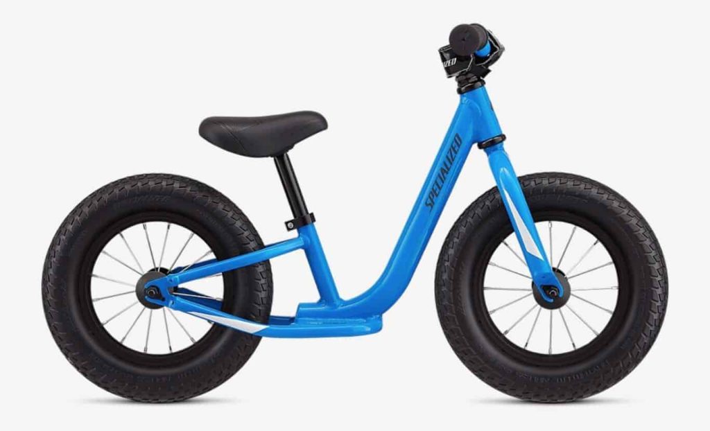 Blauwe loopfiets met brede banden voor kinderen, ideaal voor eerste fietsplezier in de wintersport.