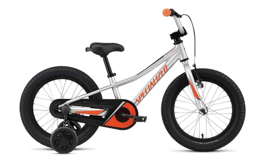 Kleine kinderfiets in zilver en oranje met zijwieltjes en sportief design.