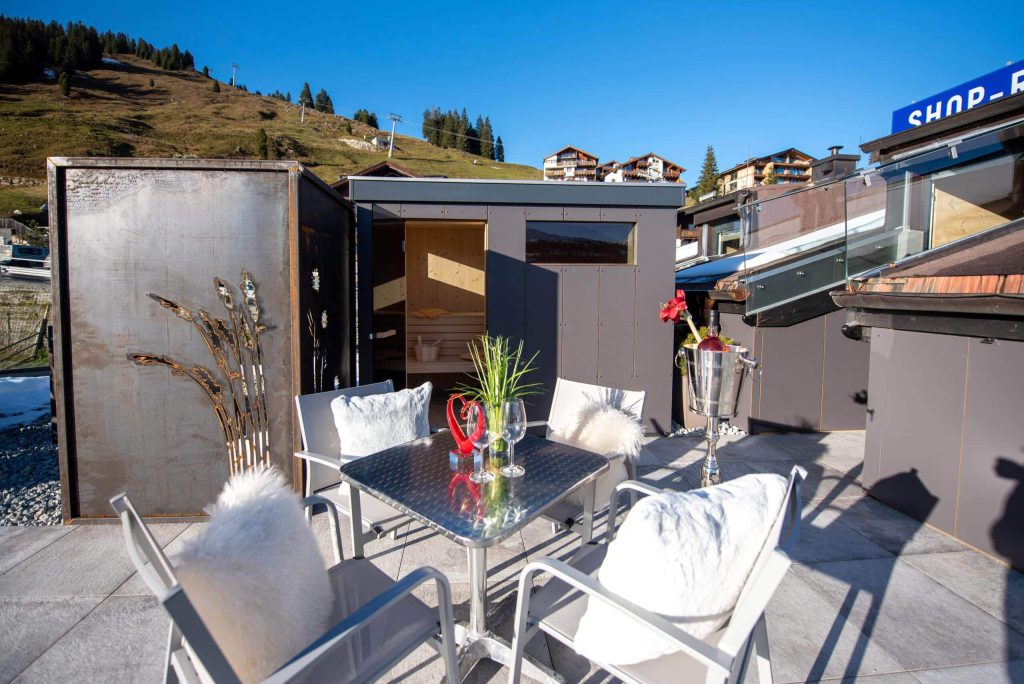 Gezellig terras met tafel en stoelen, omringd door Alpenlandschap in Königsleiten.
