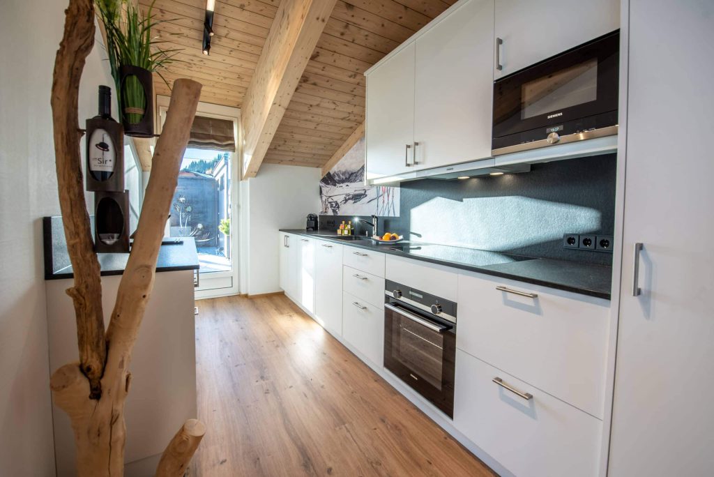 Moderne keuken met houten plafond en uitzicht naar buiten, ideaal voor skivakantie in Königsleiten.